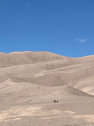 People are just wandering up the dunes. Where are they going?  