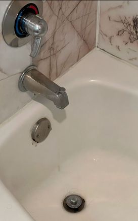 Retro tub faucet handle, accompanied by grout mildew
