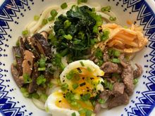 Udon noodle soup with stir fry beef, soft-boiled egg, shiitake mushrooms, spinach and spicy bamboo shoots