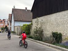 Kids chasing each other round the block on their bikes 