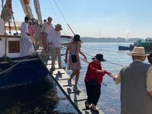 M assists some of the group off the boat