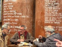 The atmospheric back room (enter by the side street) of Casa Morales....a trio of regulars sipping vino Tinto; some of th many menu offerings written on the barrels behind them.....a vast menu here!!