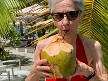 Joyce enjoying coconut water from a hollowed out coconut 