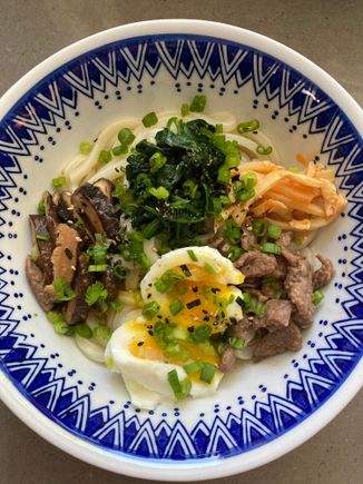 Udon noodle soup with stir fry beef, soft-boiled egg, shiitake mushrooms, spinach and spicy bamboo shoots