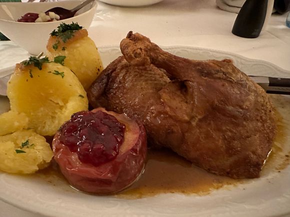 Lovely roast duck with potato dumplings and. berry-filled baked apple