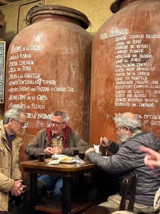 The atmospheric back room (enter by the side street) of Casa Morales....a trio of regulars sipping vino Tinto; some of th many menu offerings written on the barrels behind them.....a vast menu here!!