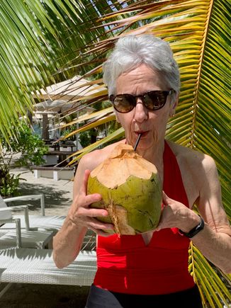 Joyce enjoying coconut water from a hollowed out coconut 