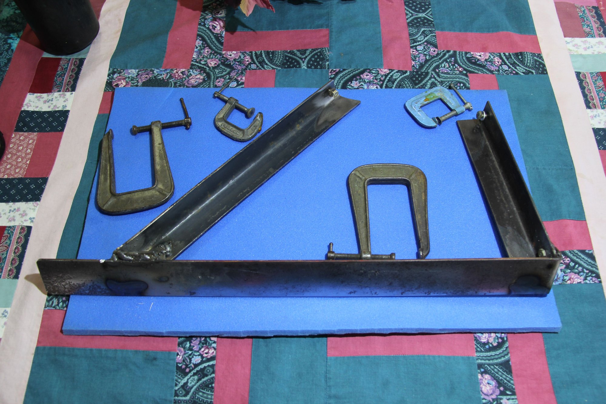 This  is  the  part  that  attaches to  the one  on  the  firewall..  The  welding   isn`t  up  to  Fords  standard  but  to  tack  weld  the two  angles  ,you  can`t  even  see !!  So  put  the  torch  head  in  there  , pray,  and  pull  the  trigger..   The  far  end  gets  bolted  or  you  would  not  be  able  to  install  the  unit..