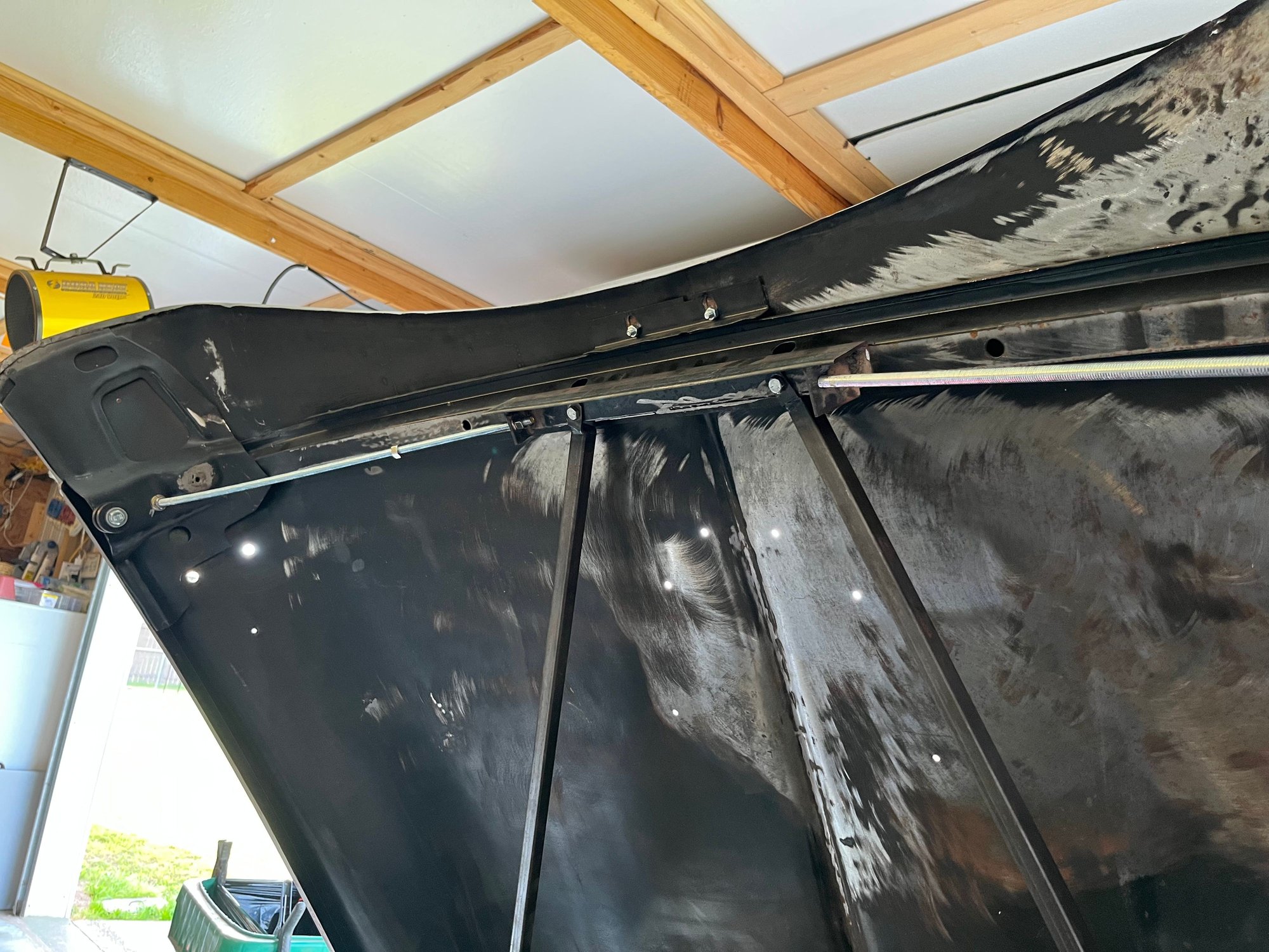 Attached bracket. The bolts on the inside allow to adjust each side of the hood. 