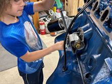 So we jumped to the other side I took the manifold back off and then cracked the motor bounce loose and then let him take them off. He’s still at that age where he really likes to do the ratchet and then I handed him the hammer and I held the center punchand let him knock the freeze plugs out of this side. Yes, under my breath I was praying he didn’t slip off and hit my hand, but he did great of course he knocked one into the block also and we had to dig it out, but he thought it was fun getting