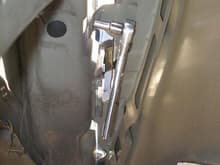 Last fender bolt removed from inside fender.  Sit partly inside the left front tire space, on a short tool, facing the back of the truck.  Rest arch of outer fender on shoulder.  When last bolt is released the fender will drop slightly to be supported by your shoulder.   Fender weighs very little.
