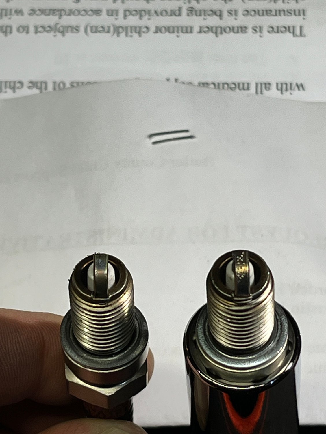 The plug on the left was the old one. The plug in the right is the Drag Specialties plug. That I only put about 50 miles on. 