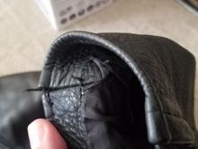 Slight damage to the stitching on the left sleeve.