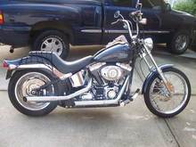 This is what it looked like after I replaced the stock seat, lowered it a little, pushed the handlebars up, and put on some louder pipes.  (I have since removed the bungee web from the back fender... bad idea putting it that tight, b/c it was rubbing the paint a little too much.) Recently, I added the Arlen Ness 3" forward control extenders (not shown here), and now I can stretch my legs out on it... I like them a lot.