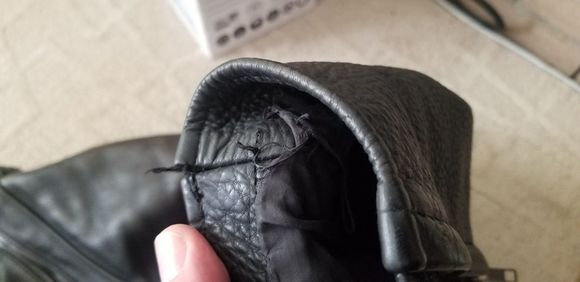 Slight damage to the stitching on the left sleeve.