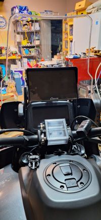 The view from the cockpit. The roll chart holder is in the center on the handlebars. The Carpuride W702 is up top. The switch for the aux lights is barely visible on the left side behind the Carpuride screen.  Teh USB hub, with voltmeter, is just to the right of the roll chart holder on the handle bars.