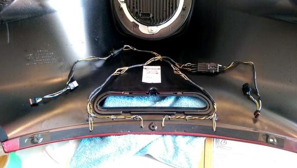 Cut weatherstrip to pass wires down through, with wires straight and parallel.  Hot melt glue wires out of the way.  Add a couple of waterproof connectors instead of the eight twist-locks.  
To get in there, pull the windshield as normal, reach in and disconnect 3 connectors (one for the headlight) and DONE.  No juggling.