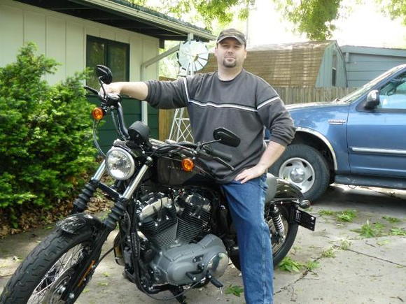 Me on the Nightster before any mods.  Hell, I think it had like 7 miles on it when I took this picture.  There's a bunch of crap on the ground from a real bad storm we had the night before.