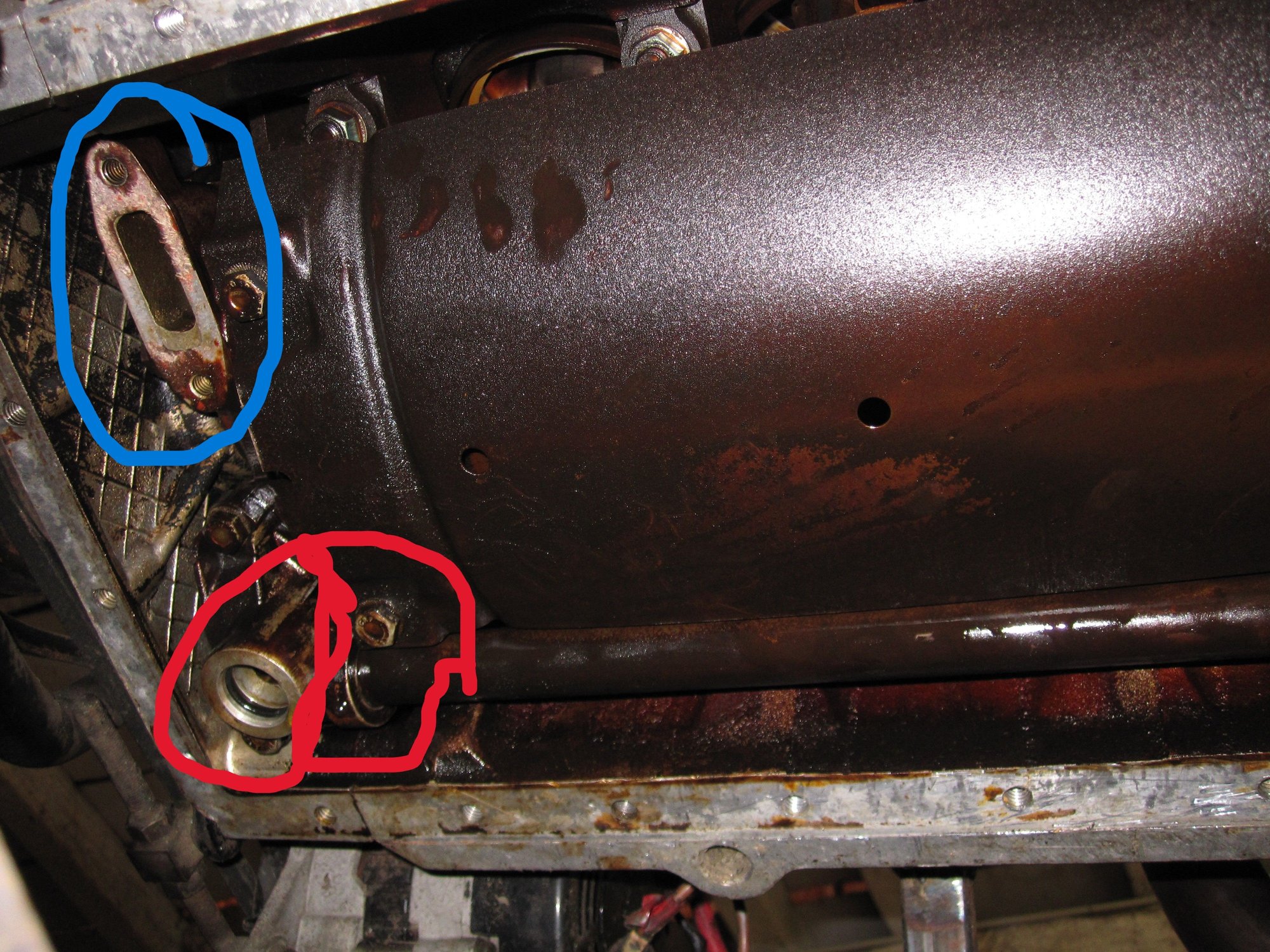 Blue rinf shows the pump output connectioins to the oil galleries. Red ring shows (round connection circled) the oil cooler return feed to the pump and (pipe circled) the pipe from the sump pickup joining the casting. The TWO input to the oil pump.
