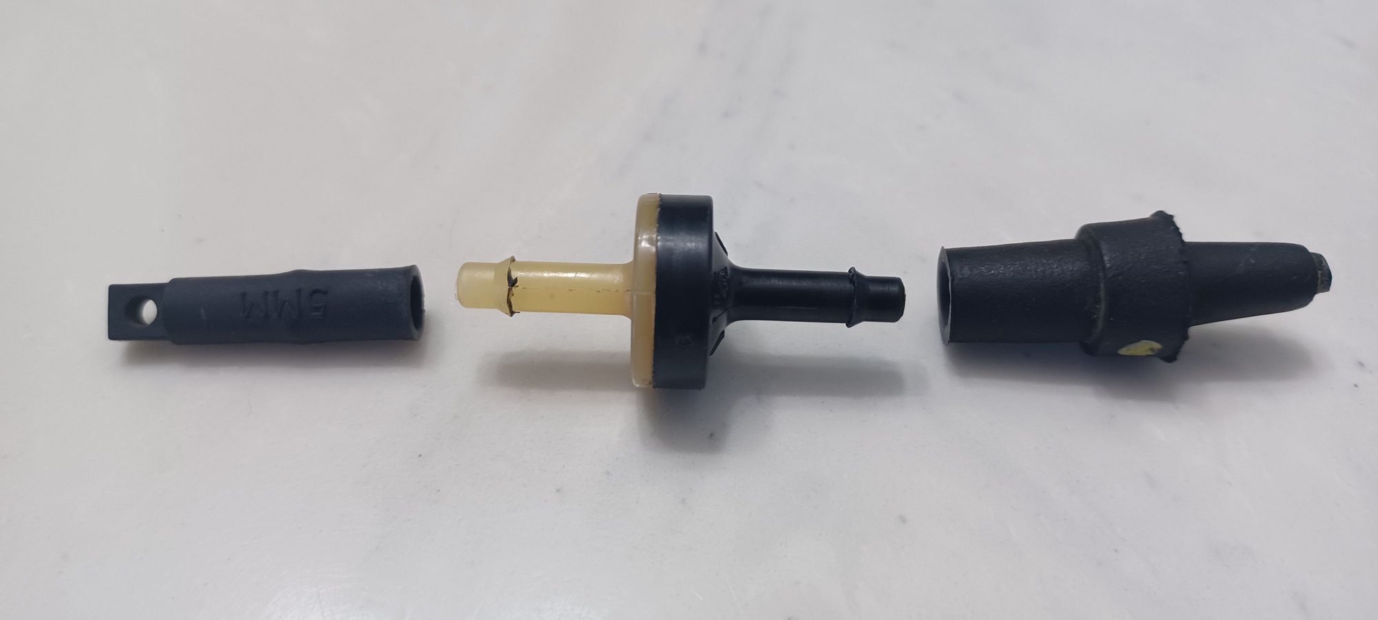 This photo shows the one-way vacuum check valve components. Left is the cap, middle is the one-way check valve and right is the female connector for the actual vacuum line.