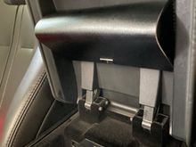 My sunglasses case happened to fit perfectly under the armrest and secured using some double sided tape. Convenient and out of the way. 