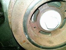 This picture shows the crankshaft bolt and the damper.  You can see the two holes for the puller bolts in the damper.