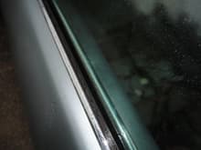Passenger door showing short edge of seal at the top, which does not touch glass