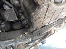 With the under tray dropped you can see the oil pan drain plug on the right rear side of the pan.