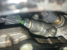 Engine Oil Temp Sensor is the one with the yellow wire. Oil pressure sensor is the one with a single black/green wire.