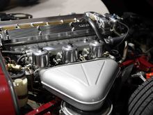 The black crinkle paint on the covers have been polished. Chromed high output alternator, triple CUs, cam valley painted Jag gold, electronic distributor, NGKs, battery cutoff, Koni shocks all around.