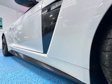 Carbon fiber print PPF “blade” panel behind the front fender vents and on the side skirts. (Also clear PPF on the whole front clip and on the rocker panels.)
