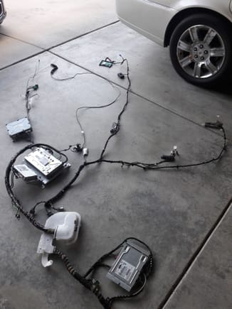 Some of the entertaiment components laid out connected by the telematics harness before starting. They we're stripped from a salvaged XJL.