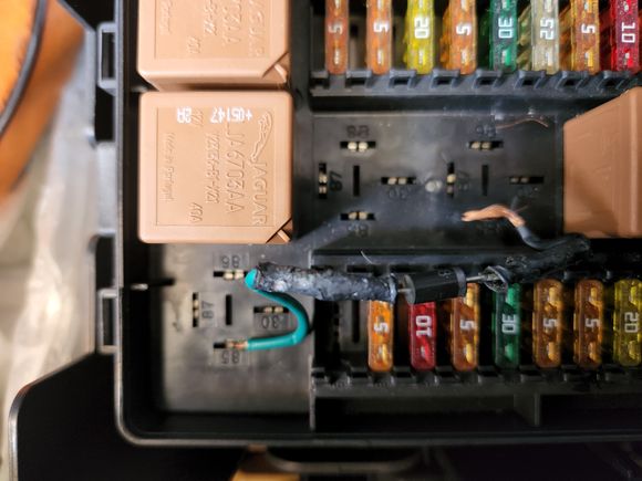 Front fuse box with relays removed to show position of the jumper wire.
