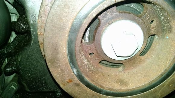 This picture shows the crankshaft bolt and the damper.  You can see the two holes for the puller bolts in the damper.