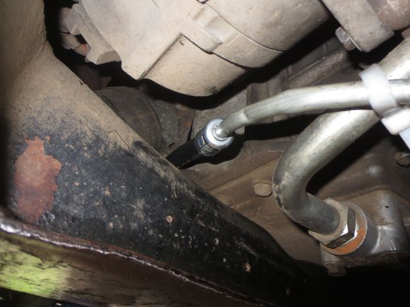 Here is the hose appearing at the front of the crossmember. The hard line is secured to the oil cooler pipe and the anti-roll bar