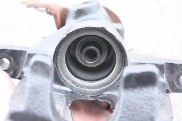 Inside shot of the caliper.  The rubber weather gasket for the piston has been removed.  But the inside piston seal is still there (black ring).