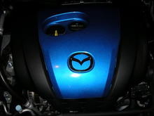 Mazda emblem wrapped in 3m di-noc carbon fiber