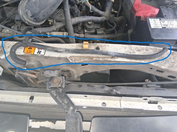 Found this random hose laying beneath Water Outlet - What did the hooked end attach to? I believe the straight end broke off of the box / part sitting below the battery.