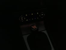 This photo exaggerates the difference.  It captures the color of the shift knob fairly accurately, but it makes the rest of the dash illumination appear too yellow.