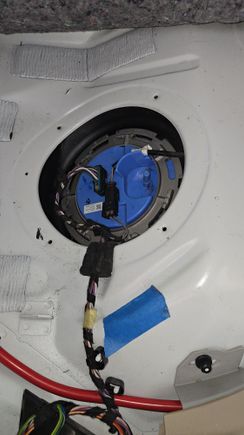 This is the fuel pump which is located under the rear seat on the passenger side. You must remove this in order to disconnect the hoses from the fuel pump and you will pull the hoses out through the other side from the driver's side rear.