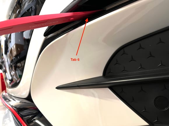 This tab near the pointed end of the spoiler is the only one along the inside edge of the trim.