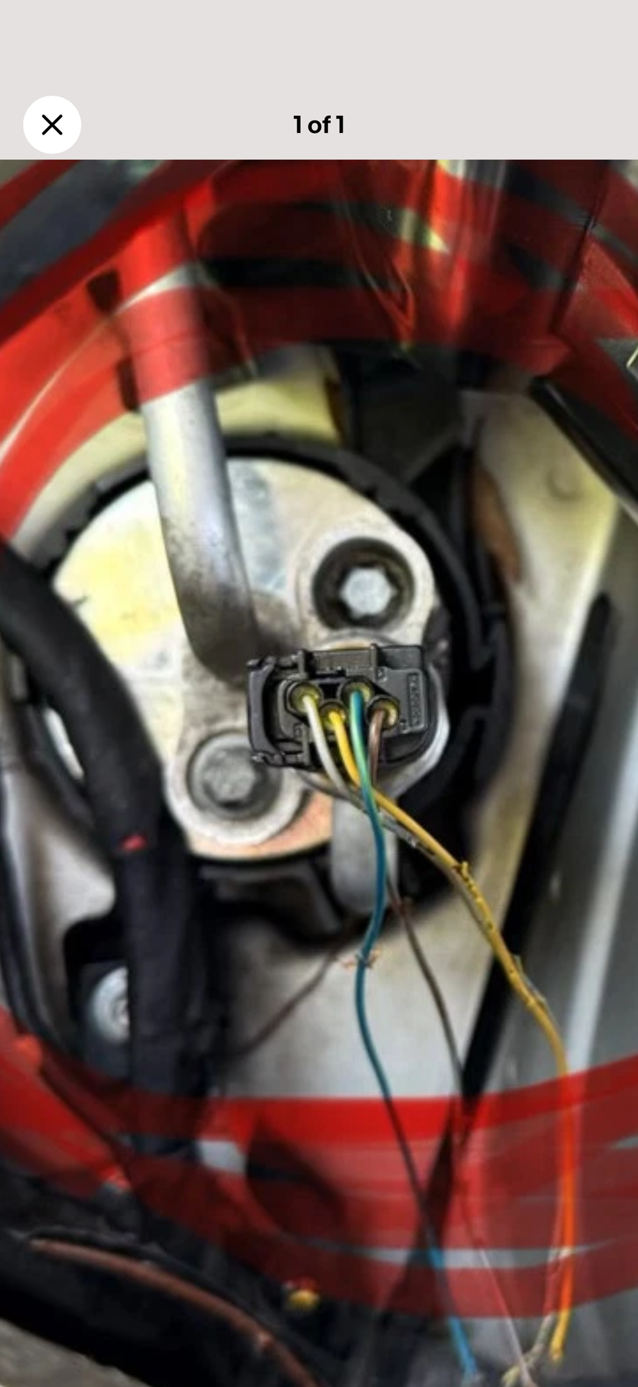 This part is located on the drivers side near the back of the left front headlight. 