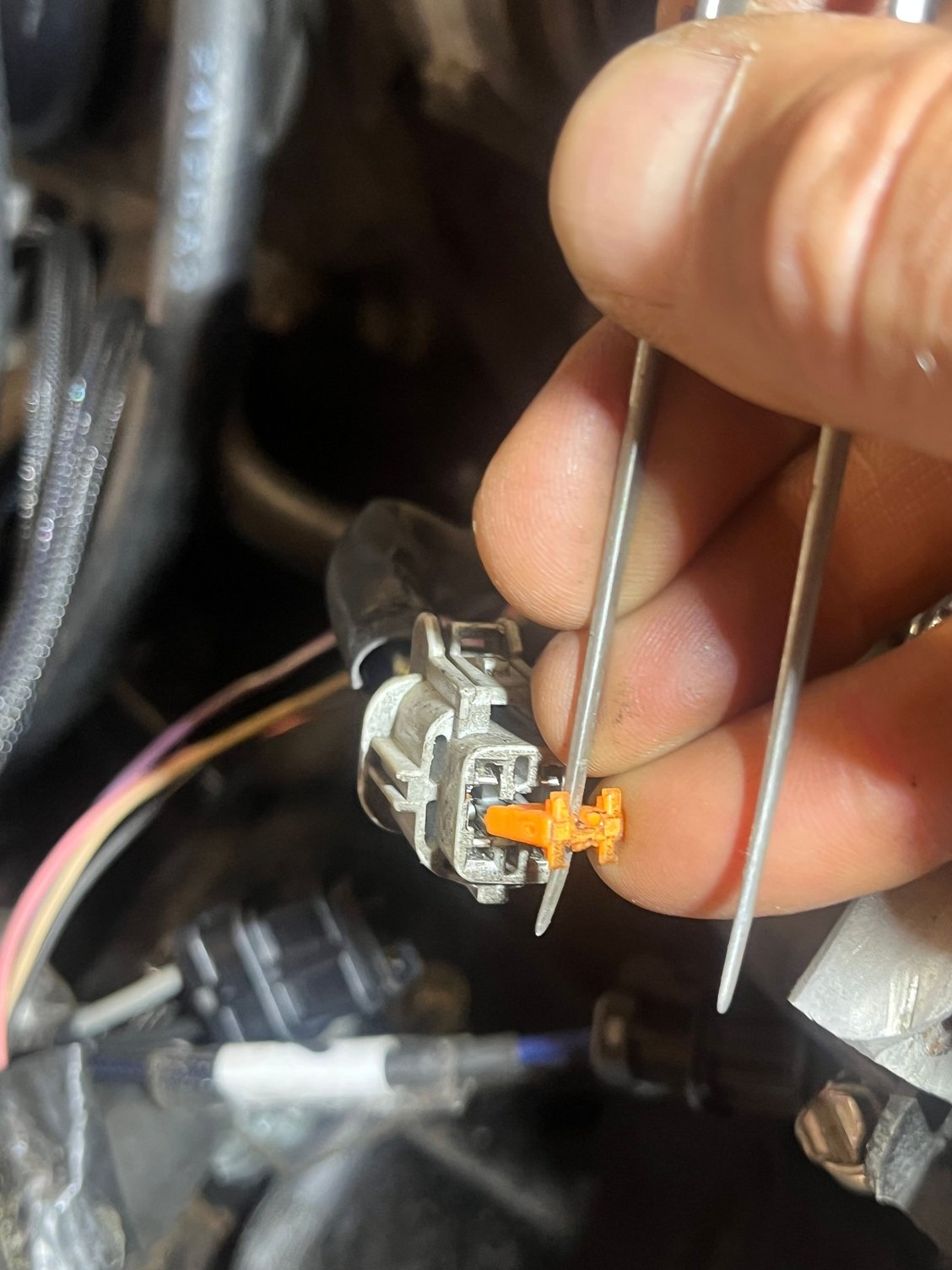 Pulling the orange tab holds the wires. 