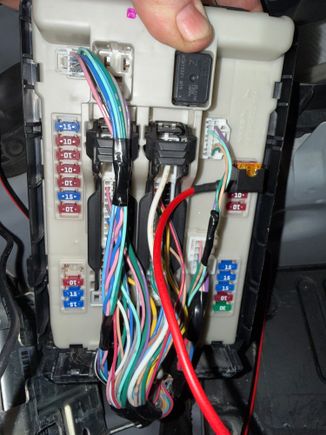 IPDM fuse box next to the battery. Not easy to remove as the two clips allowed some movement, but not enough to remove. I was almost ready to give up tugging on it, but then the box slide right out. Connect the orange wire from the power harness to to taillight fuse as it controls dimming of the gauge lighting. Works perfectly to dim the gauge lighting 30% when the lights come on. 