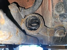 The bad FL rear control arm bushing on the vehicle after the control arm was removed.