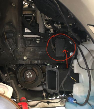 Circled is the electrical ground box mentioned earlier.  The cables running to it are in the way of the motor mount, so it has to get sung out of the way along with the washer reservoir.  The arrow points to the single nut (10mm) that holds it in place.  That nut/bolt is the connection to ground for a bunch of RF circuits -- headlight, fog light, parking light, ride height sensor, leveling control for the headlights if your car is equipped. Be sure to inspect, reconnect, & test before button-up.