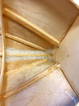 After epoxy glue and fiberglass, I used 2 part Boat Epoxy and 404 High Density filler to make a peanut butter.  When it started to setup, I went back and smooth it down with my finger for a nice transition.  I'm going to drill two small drain hole in the bulkhead/