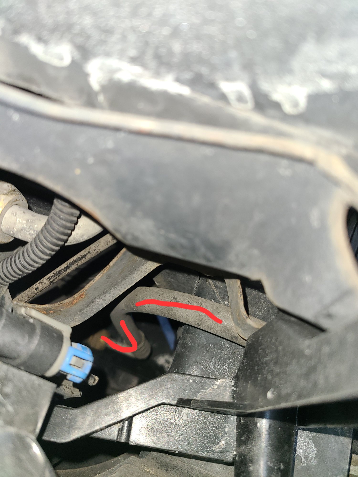 The hose starts at the condenser outlet and routes upward just underneath the headlamp bracket.