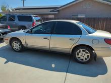 My saturn SL2 with my Sebring in the background and my dad's Suburban behind it.