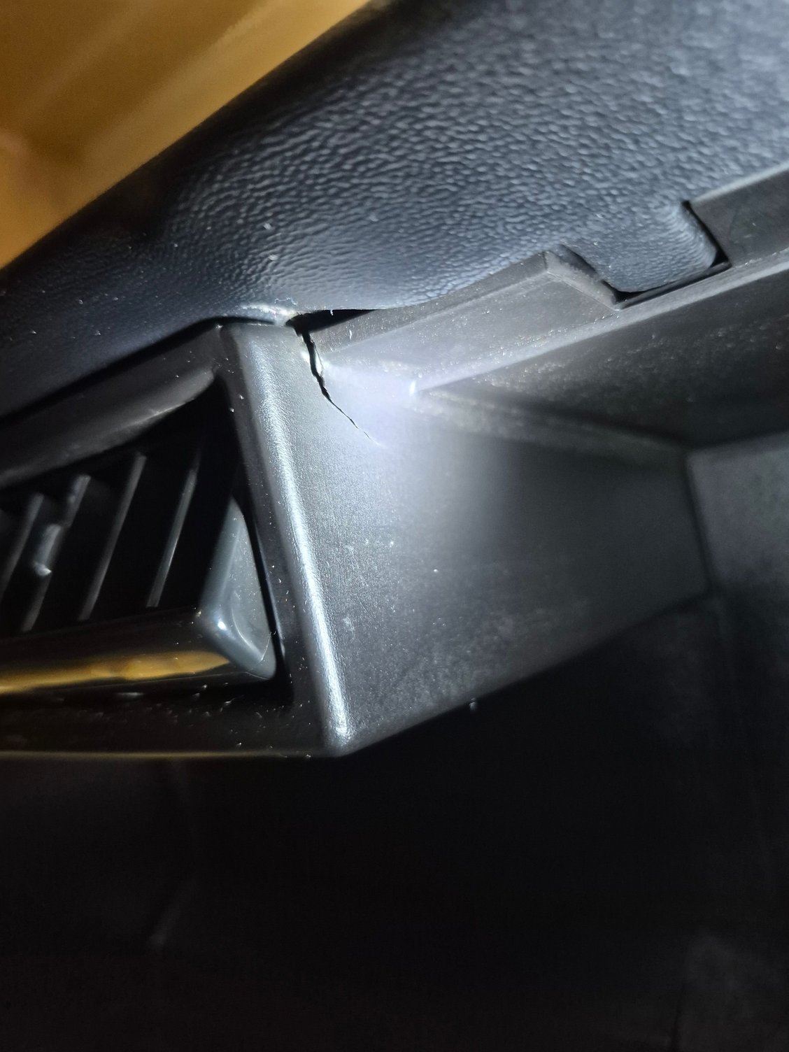 A small crack by the upper middle vents on the passenger side.